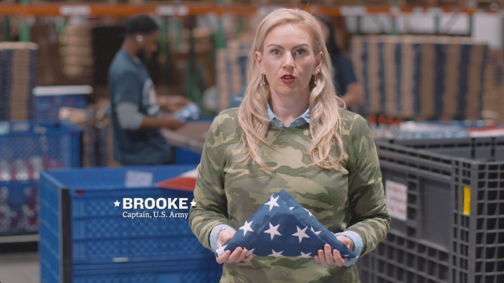 Veteran holds a folded American flag inside the Allegiance Flag Supply manufacturing facility
